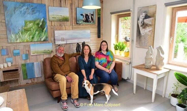 Kunstenaars Lukas, Ann en Tessa met hond Snoet tussen de kunstwerken.- Foto Marc Colpaert