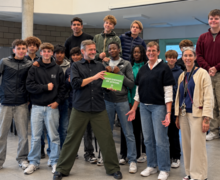 Oxfam overhandigt het WOS-school muurplaatje aan leerlingen en leerkrachten economie van het OLVRode.