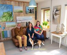 Kunstenaars Lukas, Ann en Tessa met hond Snoet tussen de kunstwerken.- Foto Marc Colpaert